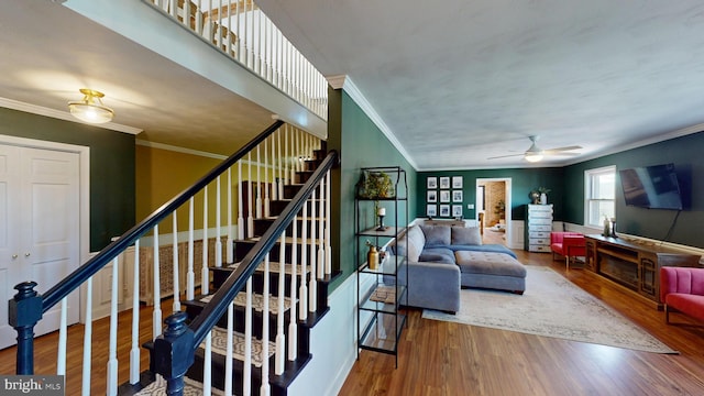 living room with ornamental molding, a ceiling fan, wood finished floors, and stairway
