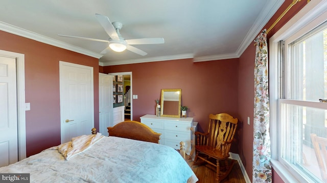 bedroom featuring baseboards, ornamental molding, a ceiling fan, and wood finished floors