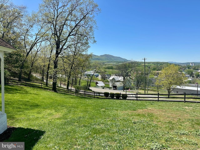 view of yard featuring fence and a mountain view