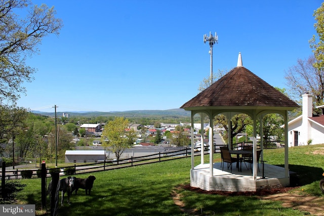 view of property's community featuring a gazebo, a mountain view, fence, and a yard