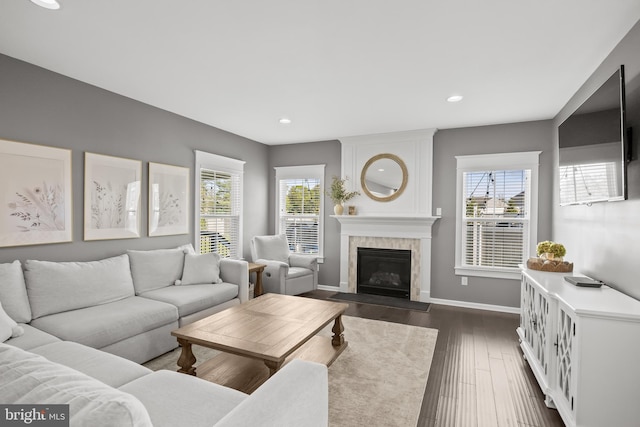 living room with recessed lighting, baseboards, a wealth of natural light, and a large fireplace