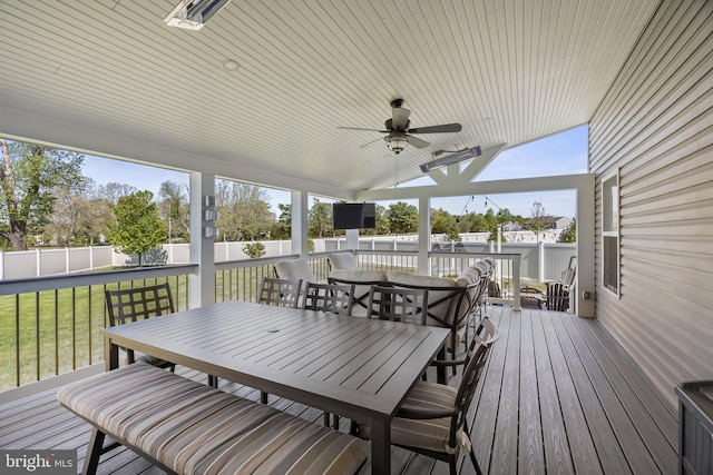 deck featuring a fenced backyard, a ceiling fan, outdoor dining area, and a yard