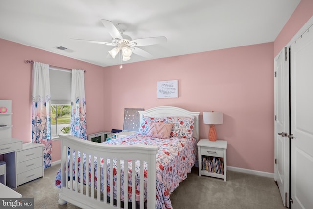carpeted bedroom with baseboards, a ceiling fan, and visible vents