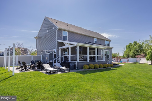 back of house with a yard, a patio, fence, and a fire pit