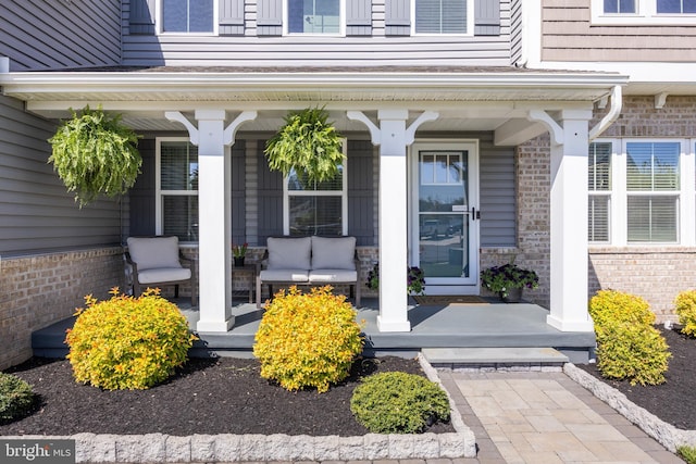 property entrance with a porch and brick siding