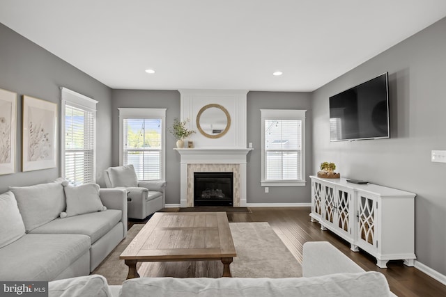 living room featuring baseboards, recessed lighting, dark wood finished floors, and a large fireplace