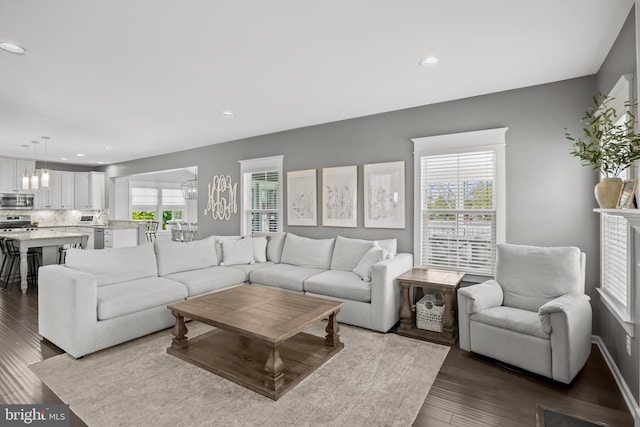 living room with recessed lighting, dark wood-style flooring, and a chandelier