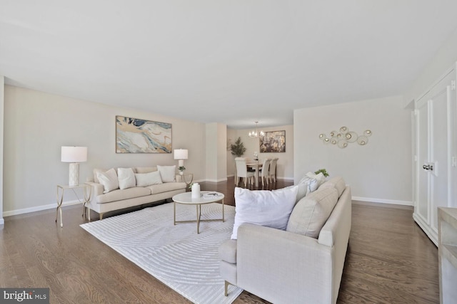 living area featuring baseboards, an inviting chandelier, and wood finished floors