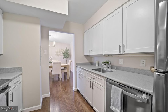 kitchen with light countertops, stainless steel appliances, white cabinets, and a sink