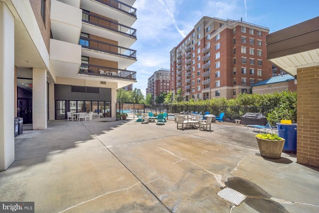 view of home's community featuring fence, a view of city, and a patio