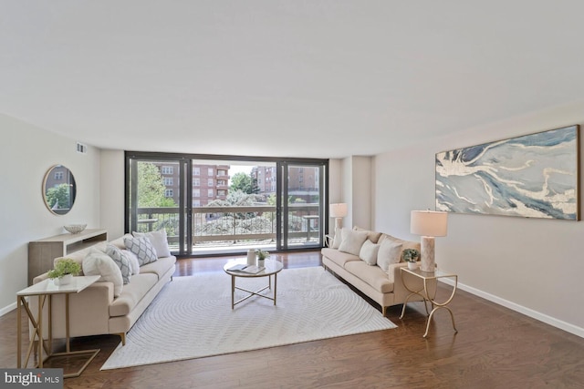 living area featuring baseboards, floor to ceiling windows, wood finished floors, and visible vents