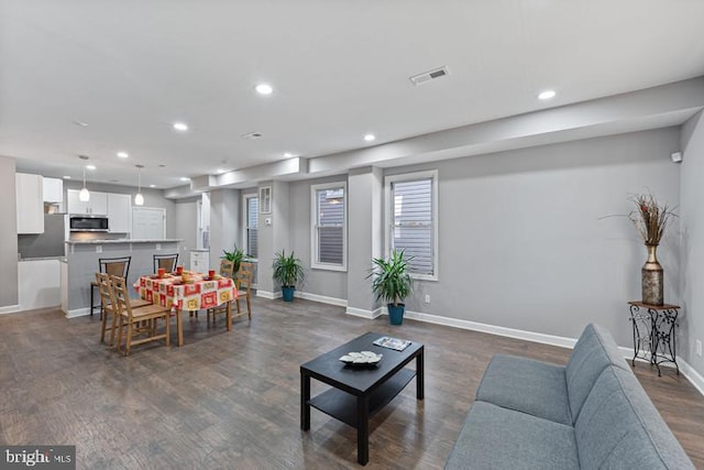 living room with baseboards, recessed lighting, dark wood-type flooring, and visible vents