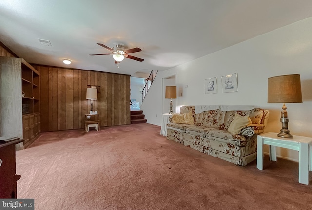 2422 Pinefield Rd, Waldorf, MD 20601 - carpeted living room featuring wooden walls, a ceiling fan, visible vents, and stairway