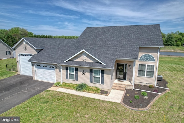 view of front of property featuring roof with shingles, an attached garage, driveway, and a front yard