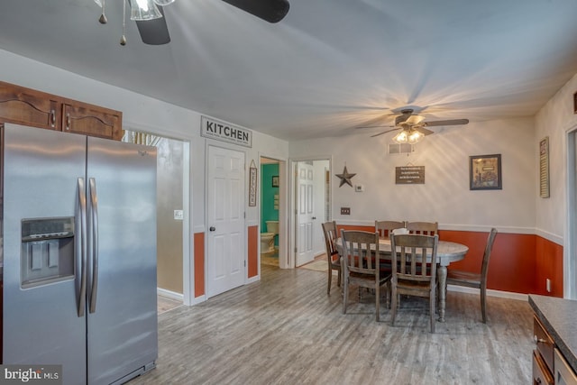 dining area with light wood-type flooring, baseboards, ceiling fan, and visible vents