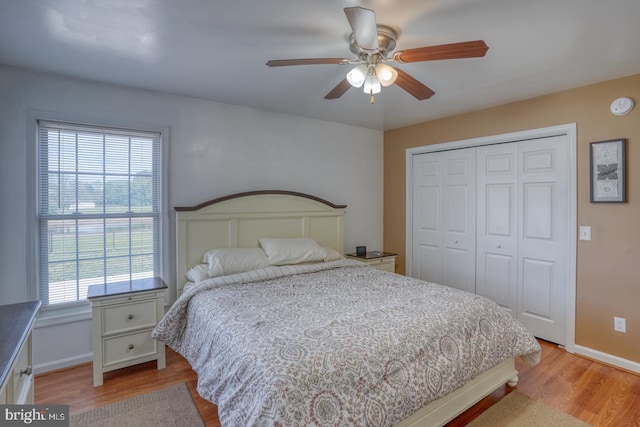 bedroom with baseboards, ceiling fan, a closet, and light wood-style flooring