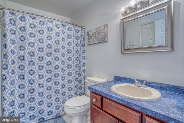 bathroom featuring toilet, a shower with shower curtain, and vanity