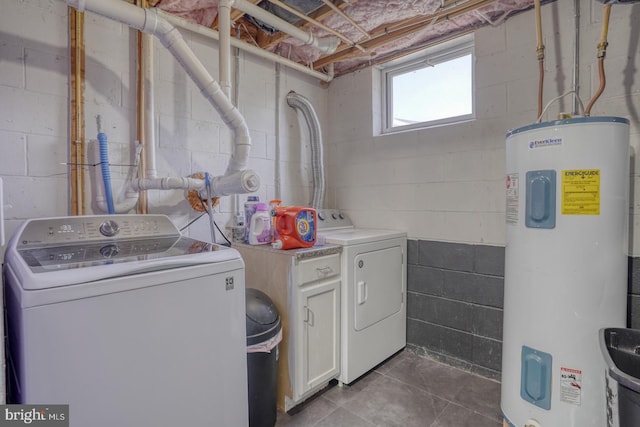 washroom with water heater, washing machine and dryer, and cabinet space