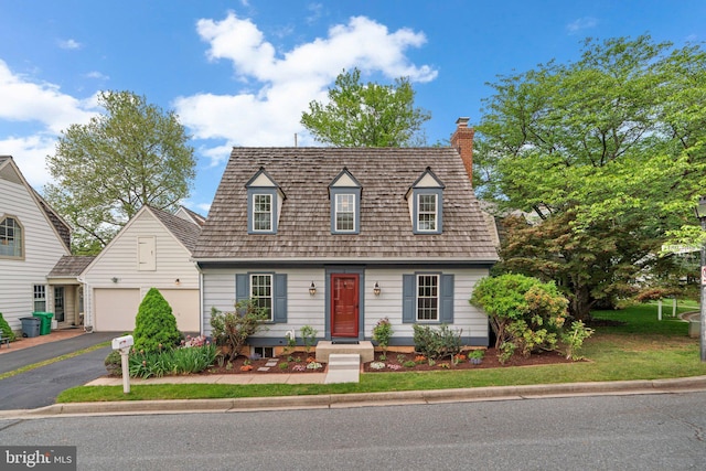 cape cod home featuring a chimney, a garage, and aphalt driveway