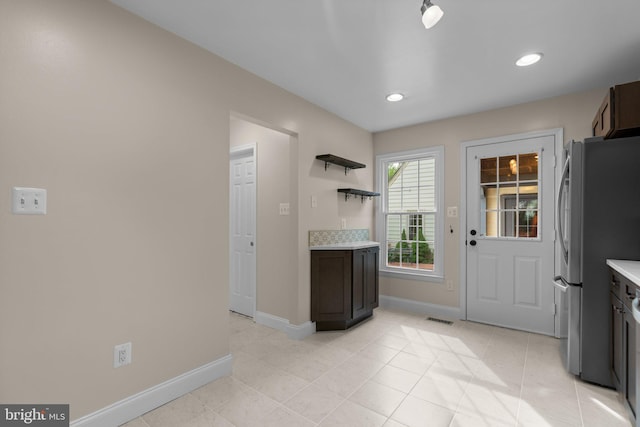 kitchen with freestanding refrigerator, baseboards, light countertops, and visible vents