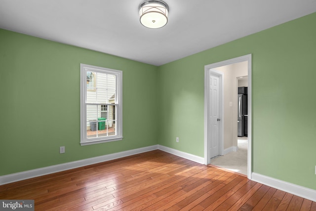 unfurnished room with baseboards and light wood-style floors