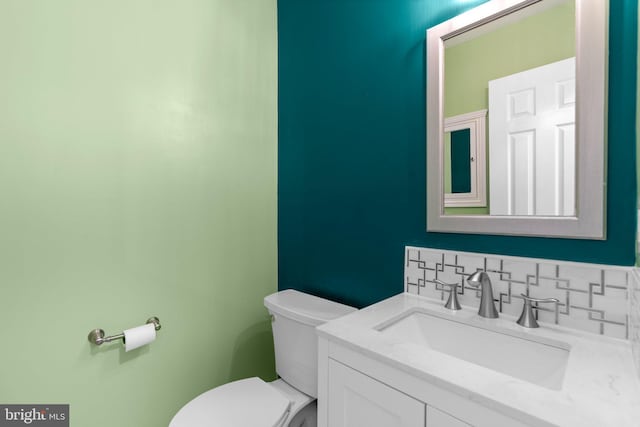 bathroom with toilet, tasteful backsplash, and vanity