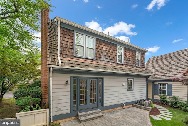 rear view of house featuring a chimney, a patio, and french doors