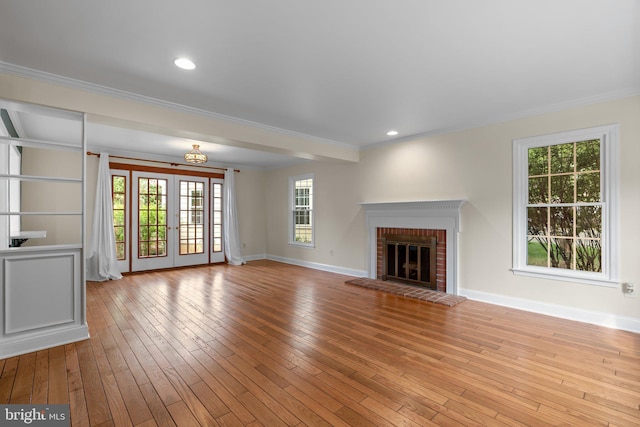 unfurnished living room featuring baseboards, ornamental molding, and wood-type flooring