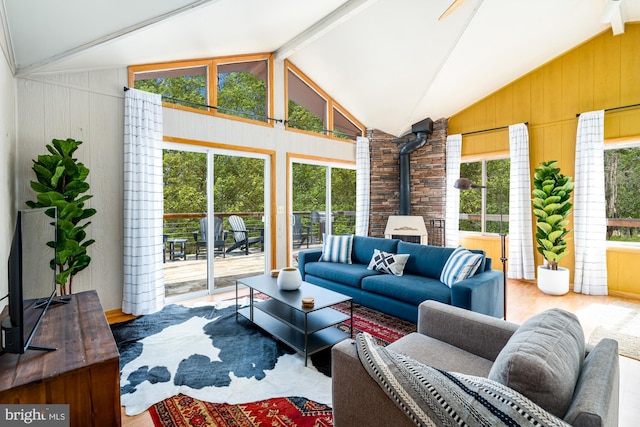 296 Mountainside Rd, Berkeley Springs, WV 25411 - living area with a wood stove, vaulted ceiling, wood walls, and wood finished floors