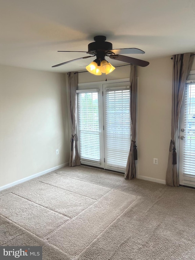spare room with baseboards, carpet flooring, and ceiling fan