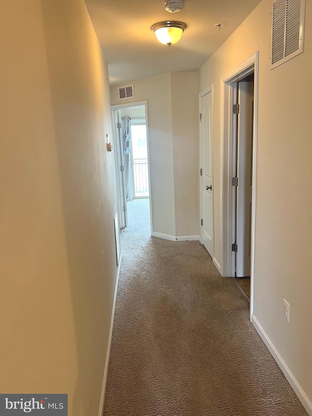 corridor with baseboards, carpet, and visible vents