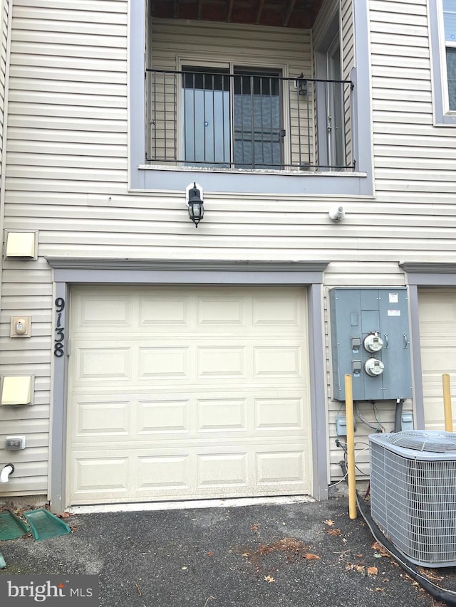 garage with central air condition unit and aphalt driveway