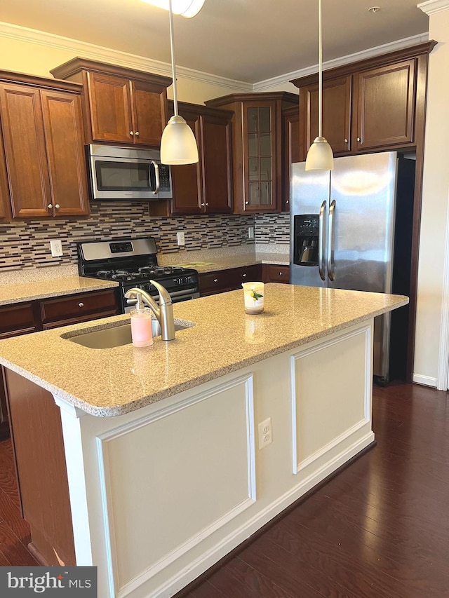 kitchen featuring tasteful backsplash, a kitchen island with sink, stainless steel appliances, and light stone countertops