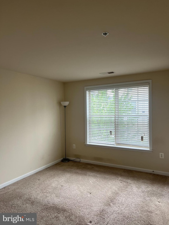 carpeted empty room with baseboards and visible vents