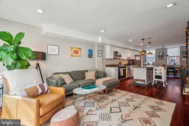 living area with recessed lighting, dark wood finished floors, bar, and visible vents