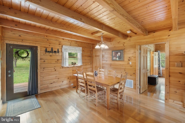 dining space with beamed ceiling, light wood-style flooring, a chandelier, and a wealth of natural light