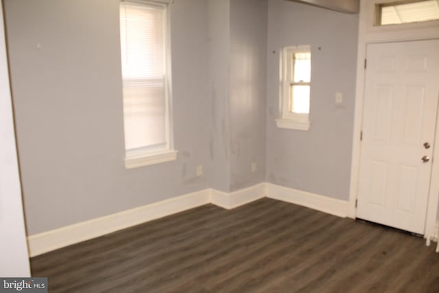 entrance foyer featuring baseboards and dark wood-type flooring