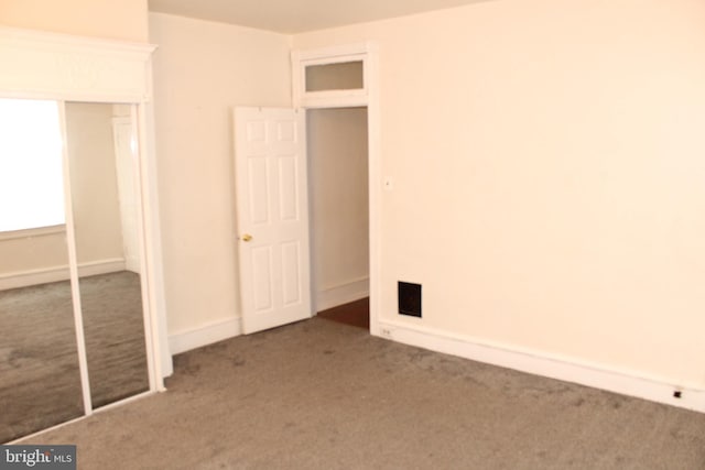 unfurnished bedroom featuring carpet and a closet