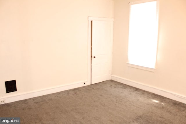 carpeted spare room featuring baseboards