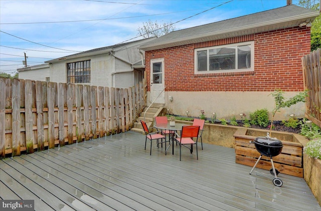 wooden deck featuring fence, outdoor dining area, and entry steps