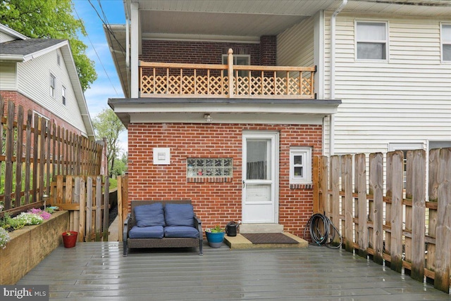 back of house with brick siding, outdoor lounge area, a fenced backyard, and a deck