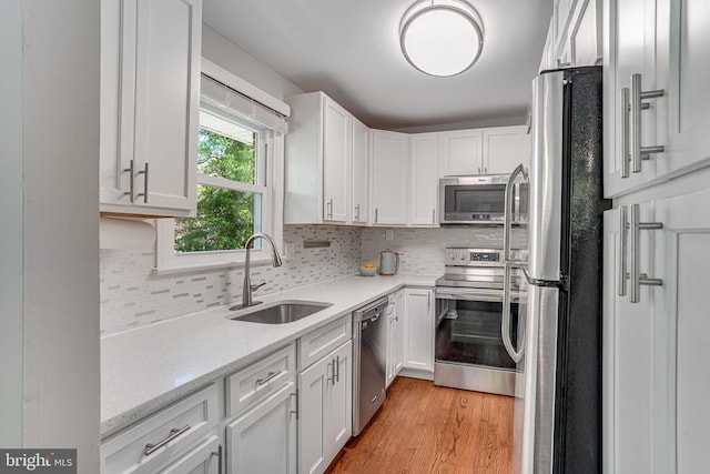 4001 Patricia St, Annandale, VA 22003 - kitchen featuring a sink, white cabinetry, appliances with stainless steel finishes, and light wood-style flooring