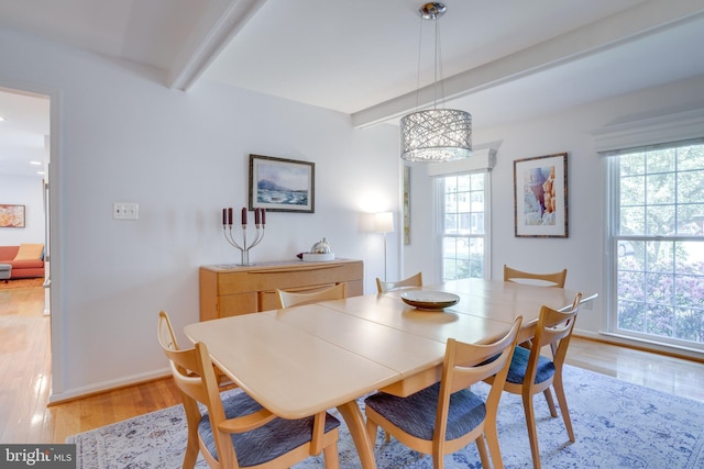 dining room featuring an inviting chandelier, light wood-style flooring, beam ceiling, and a healthy amount of sunlight
