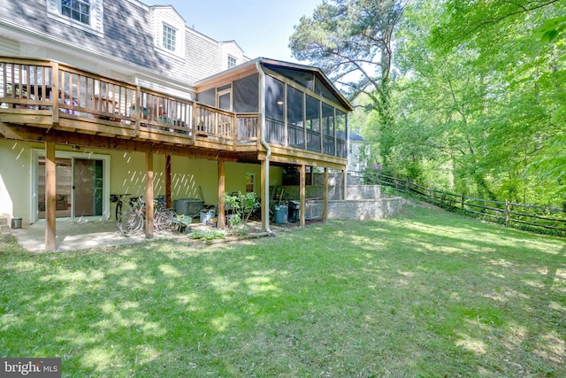 back of house featuring a fenced backyard, a yard, a wooden deck, and a sunroom
