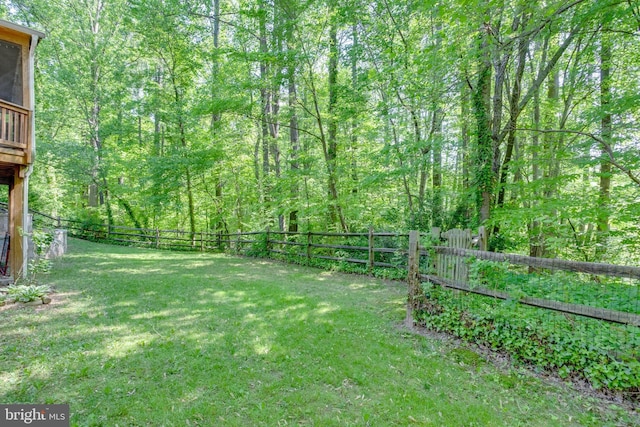 view of yard featuring a fenced backyard and a forest view