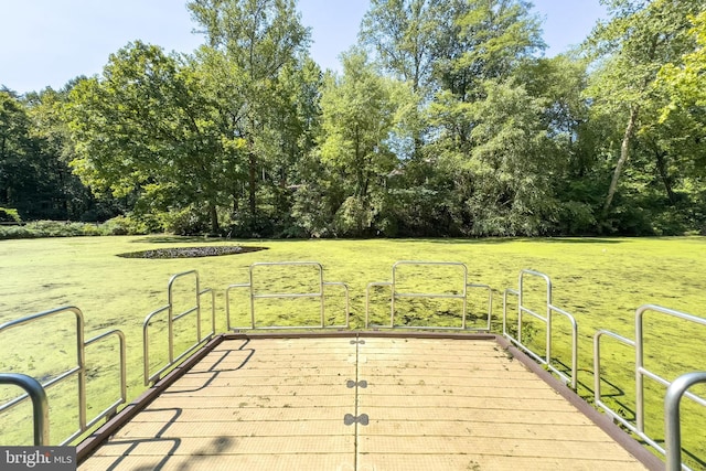 wooden terrace featuring a lawn