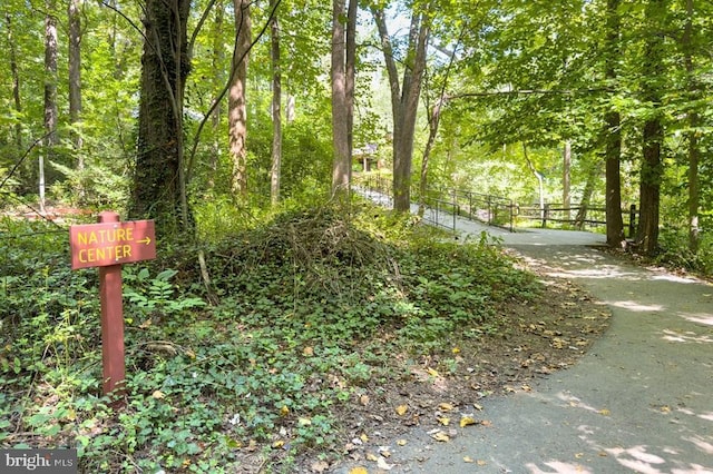 view of community with fence and a forest view