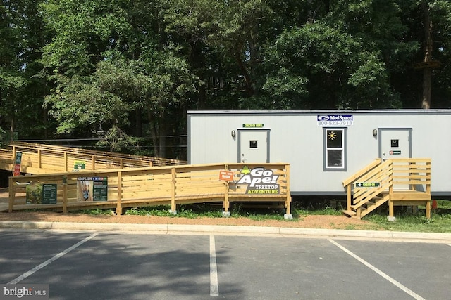 view of property featuring fence and uncovered parking