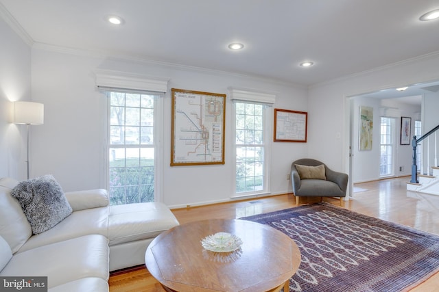 living room with stairway, crown molding, and wood finished floors
