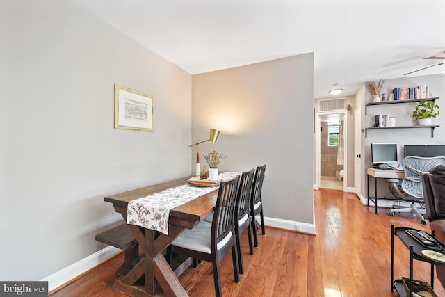 dining room featuring baseboards, light wood-style flooring, and visible vents